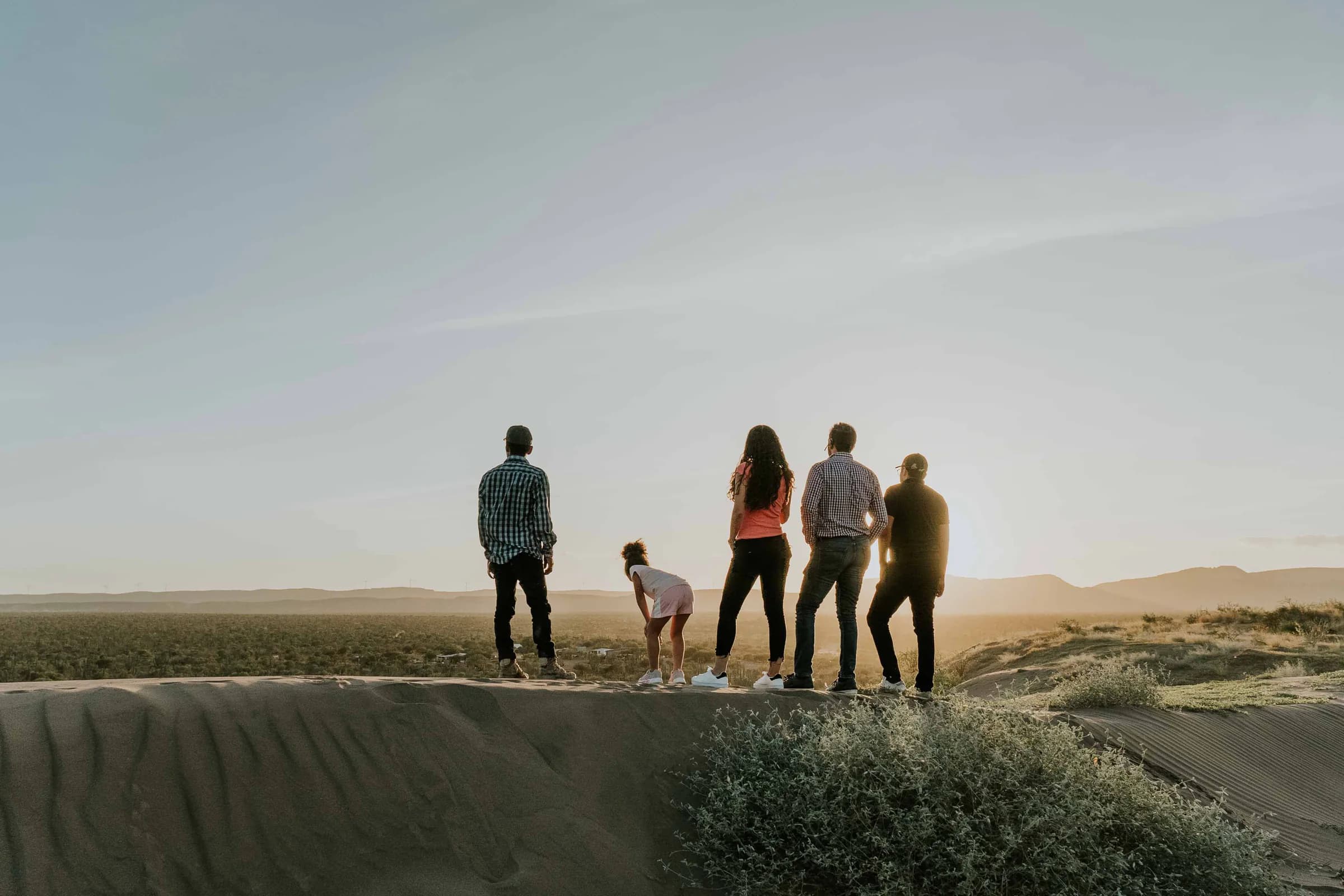 A group standing together in an open landscape at sunset
